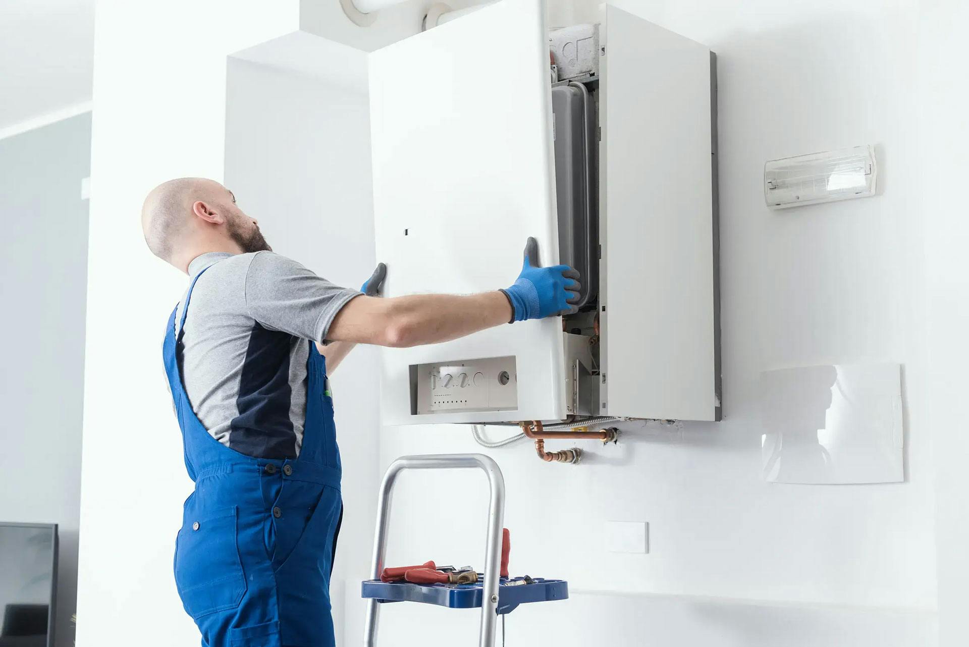 An engineer installing a wall-mounted boiler