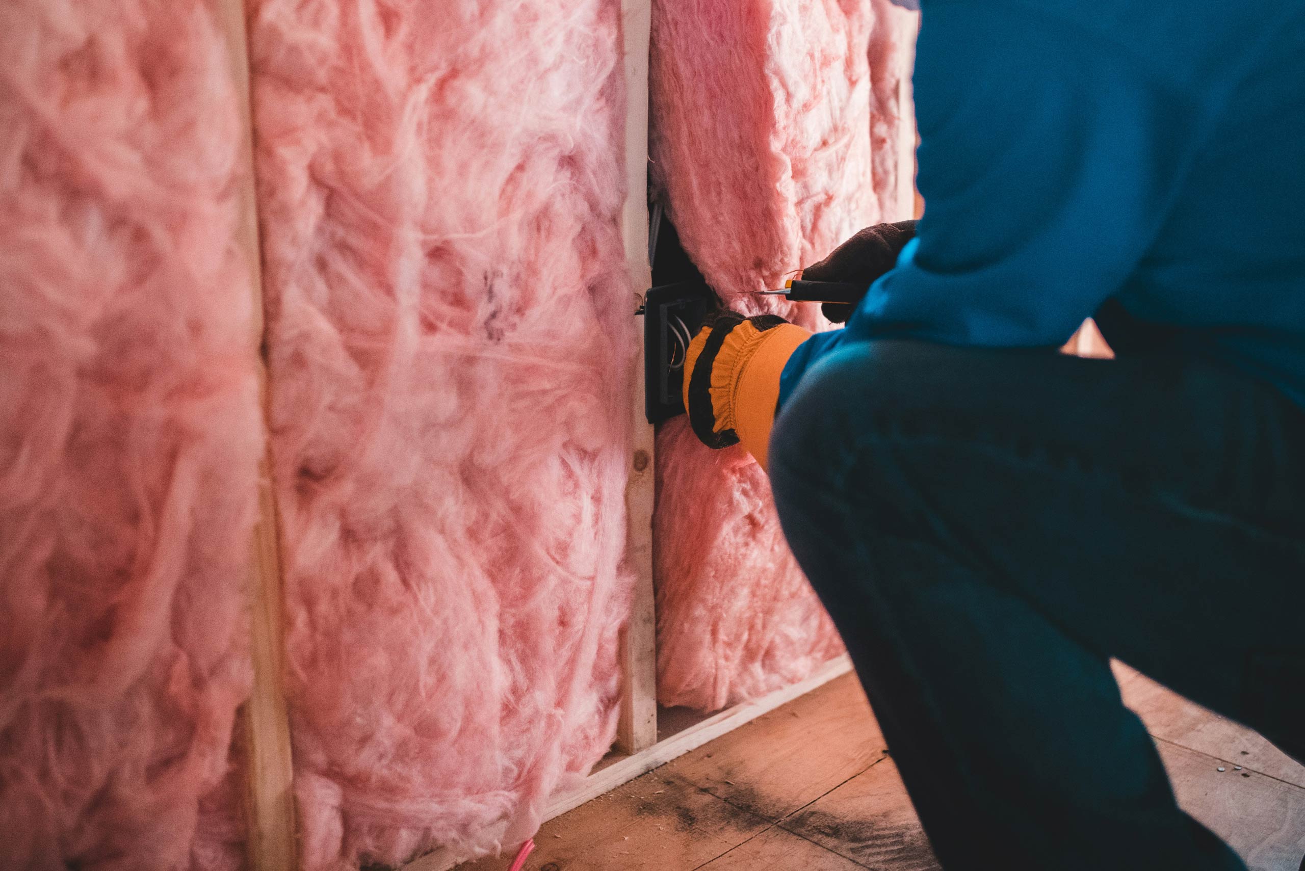 An engineer installing wall insulation in somebody's home