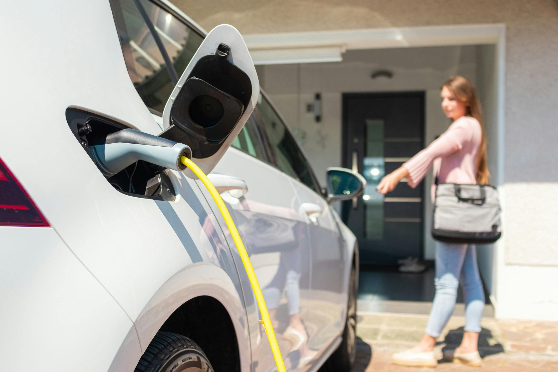 A woman charging a car with an at-home EV charger.