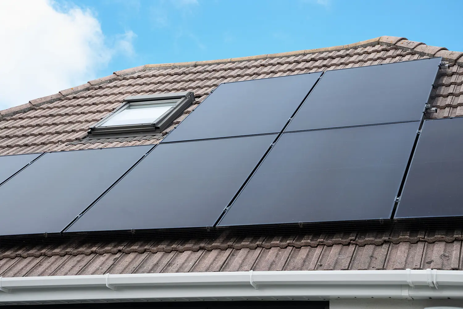 Rooftop solar panel system on a house, showing how renewable energy can protect households from rising UK energy price caps.