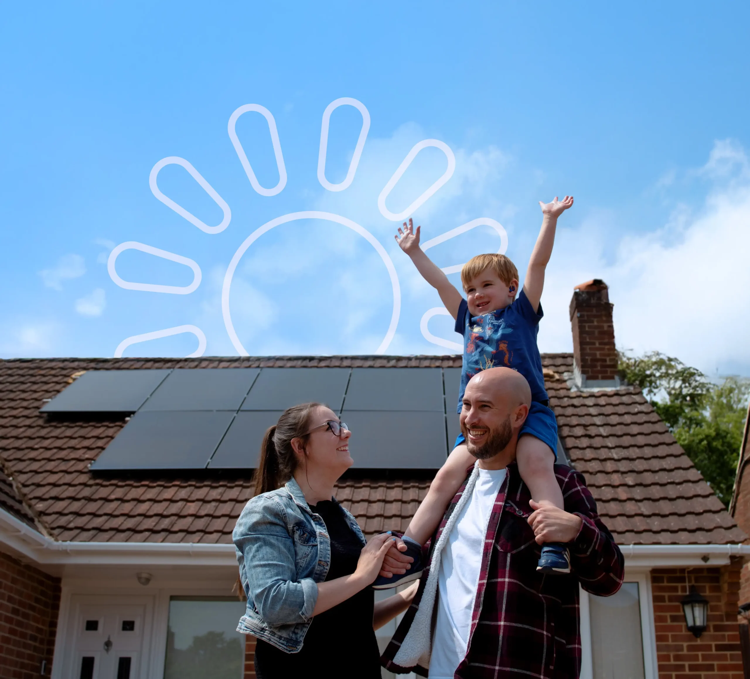 A mother & father with their son on his shoulders in front of a property with home solar panels installed.