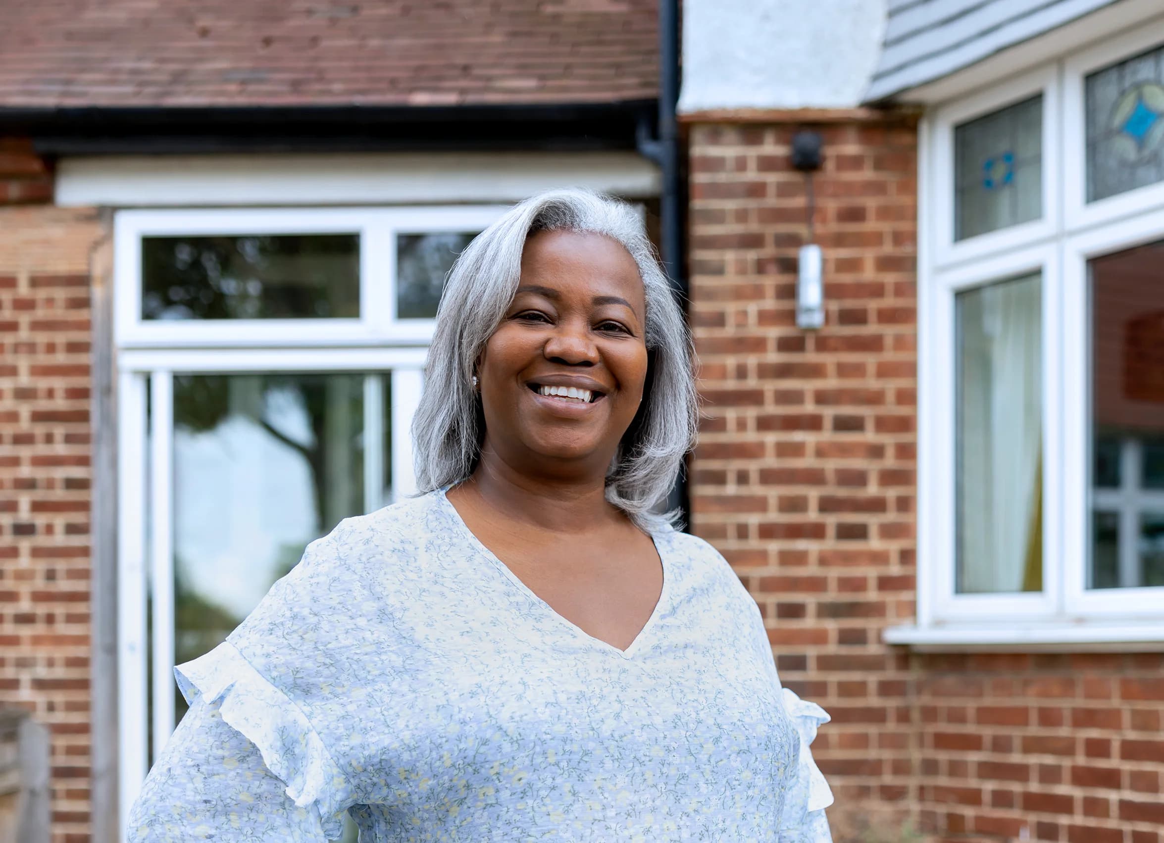 Image of a woman named Tammy, a Utilita Home customer, smiling about reducing her energy bills with solar panel savings.