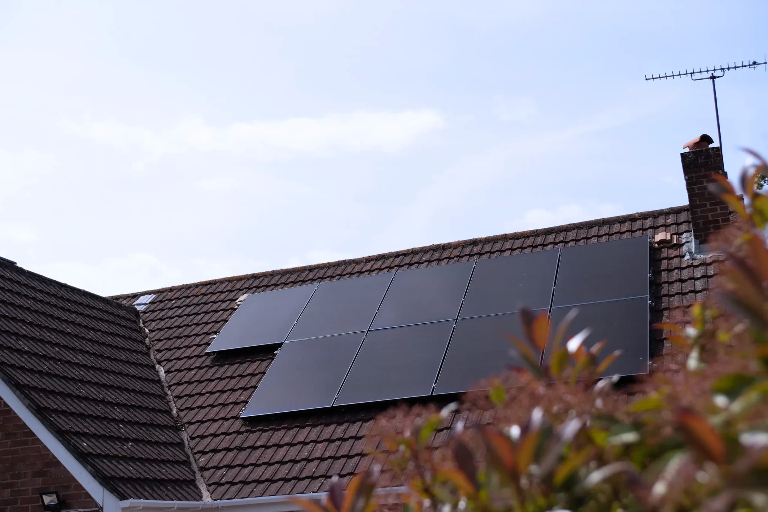 Solar panels on a tiled roof under a clear sky, showing how homeowners can reap solar panel benefits even on crisp winter days.